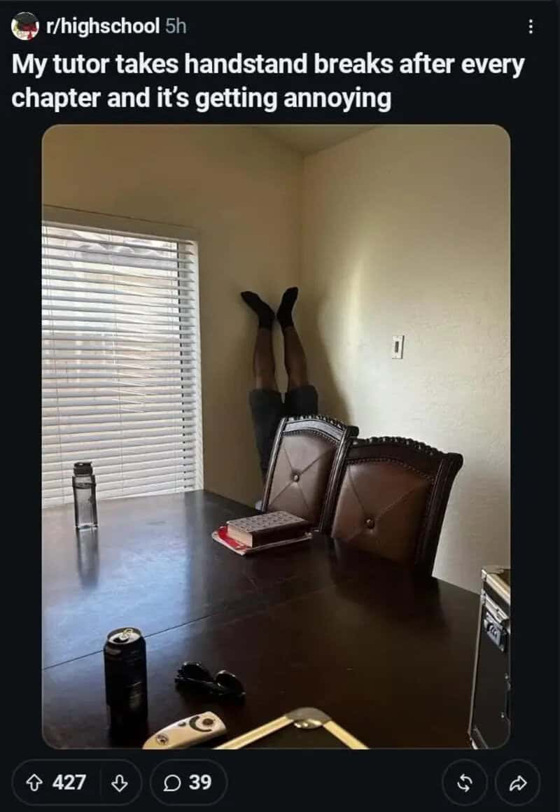 Tutor doing a handstand against the wall behind a dining table during study time