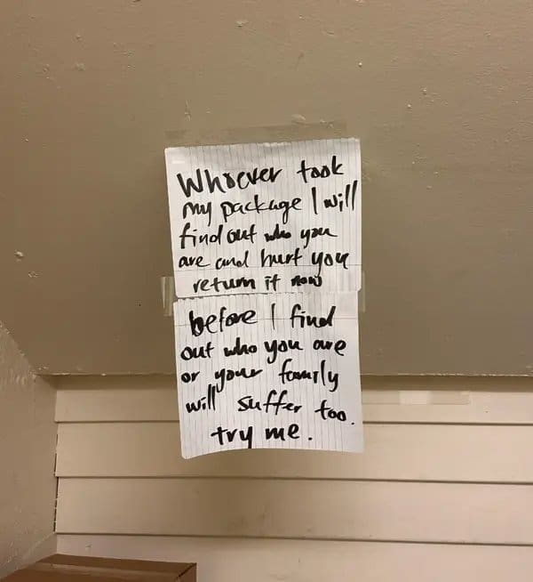Threatening handwritten note taped to a wall demanding that a stolen package be returned.