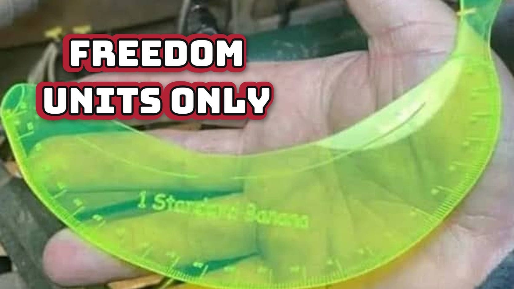 Hand holding a green banana-shaped ruler labeled one standard banana, the American not using metric system at its finest.