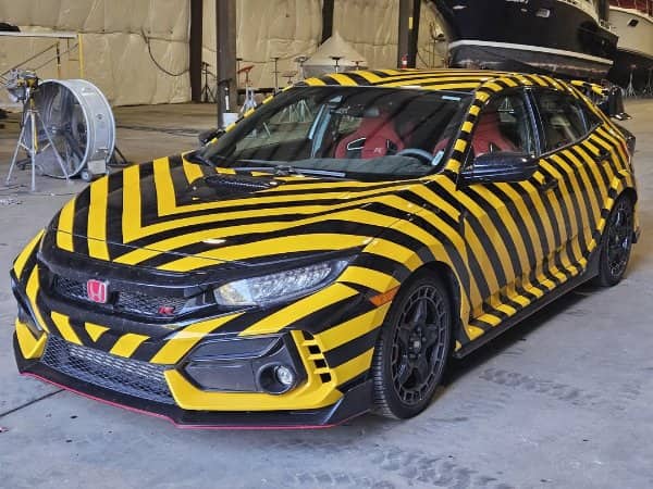 Honda Civic Type R wrapped entirely in yellow and black hazard chevron stripes