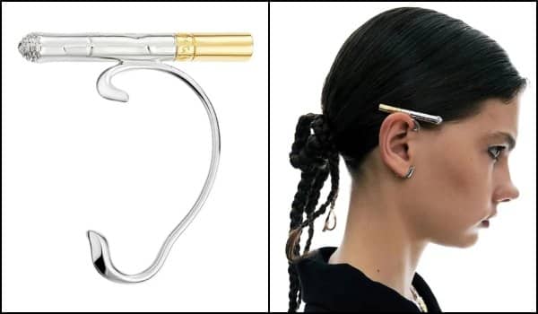 Silver and gold ear cuff shaped like a cigarette, modeled tucked behind a woman's ear