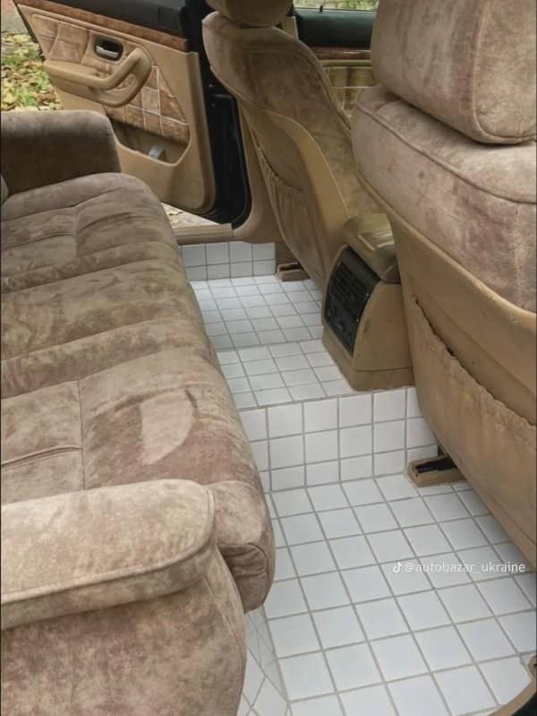 Car interior with white ceramic tile flooring and beige velour seats throughout
