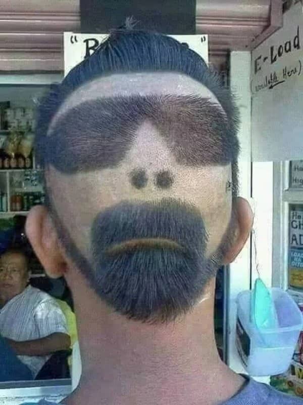 Back of a man's head shaved into a face with sunglasses, nostrils, and a goatee