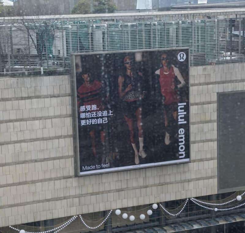 Vertical Lululemon billboard on a building with the brand name split as lulul emon