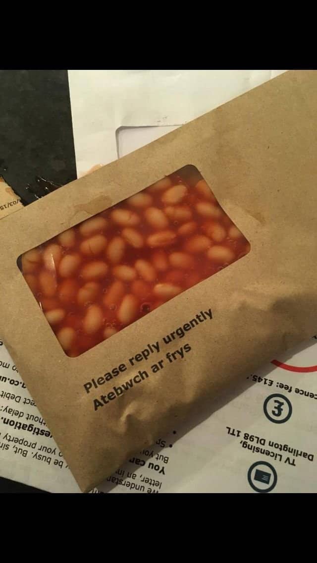Brown window envelope marked please reply urgently, with baked beans visible through the window.