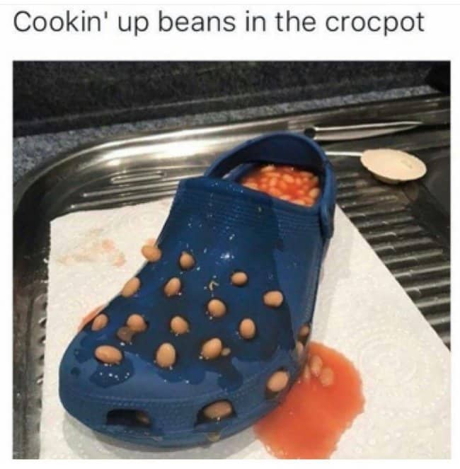 Blue Croc shoe filled with baked beans poking through the holes, captioned cooking in the crocpot.