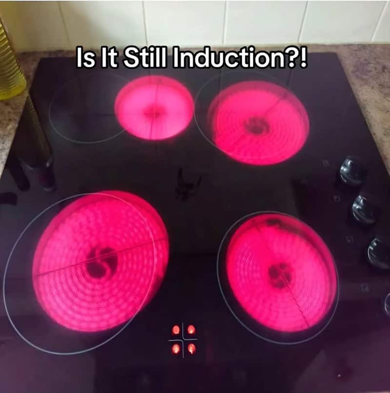 Glowing ceramic stovetop burners heating up offset from their printed circles on the glass.