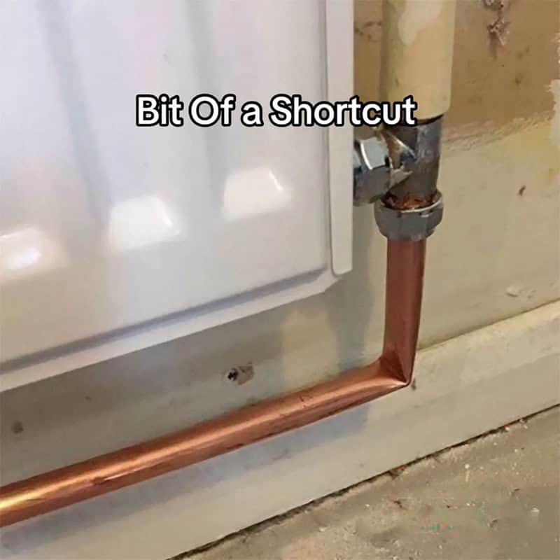 Copper heating pipe bent at a sharp diagonal across the wall instead of running neatly.