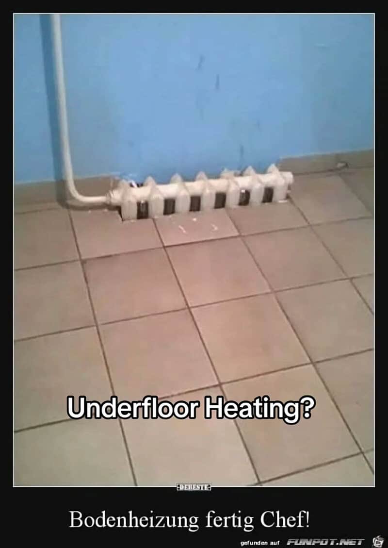 Radiator installed sunken into a tiled floor against a blue wall in a bare room.