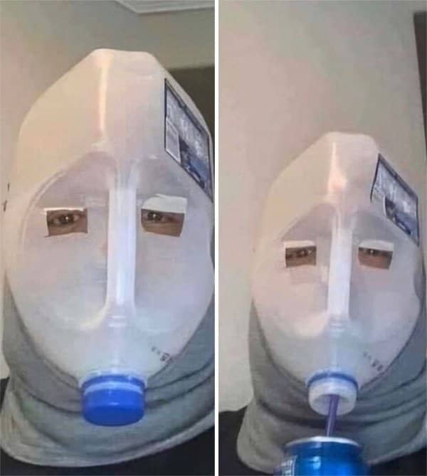 Person wearing a milk jug mask with eye holes, sipping a drink through the cap.
