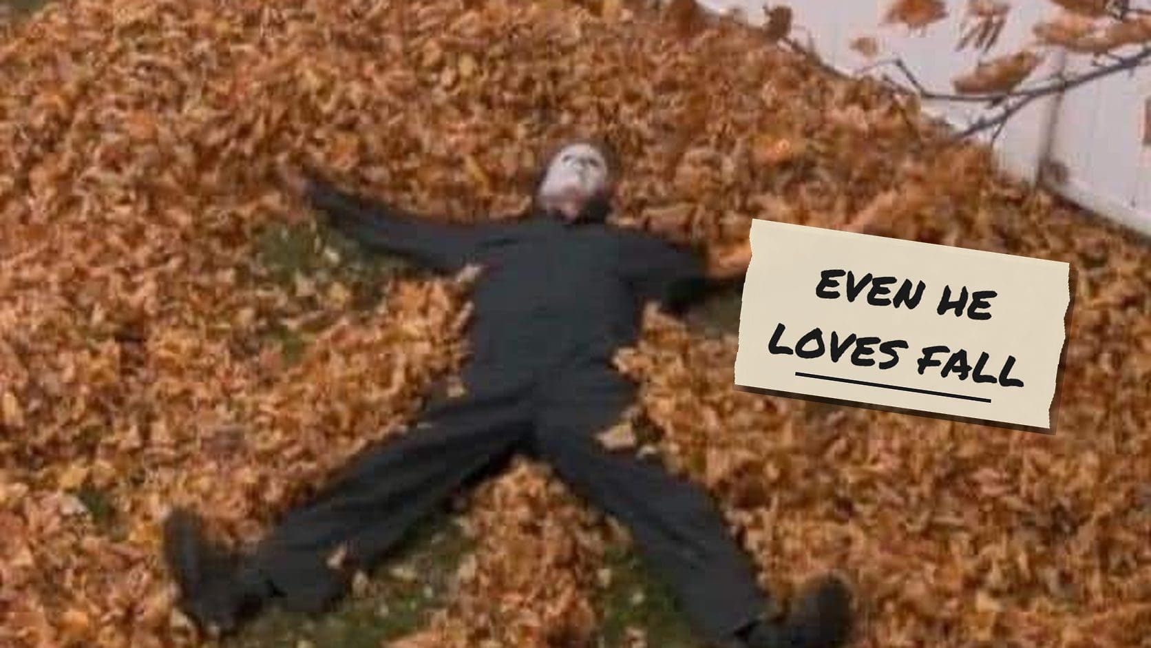 Michael Myers in his mask and coveralls making a snow angel in a pile of orange leaves, a classic among fall memes.