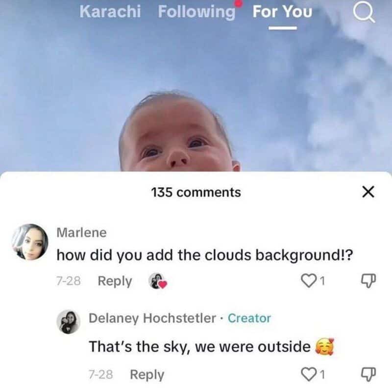 Baby looking up at a cloudy sky, with a commenter asking how they added the cloud background.