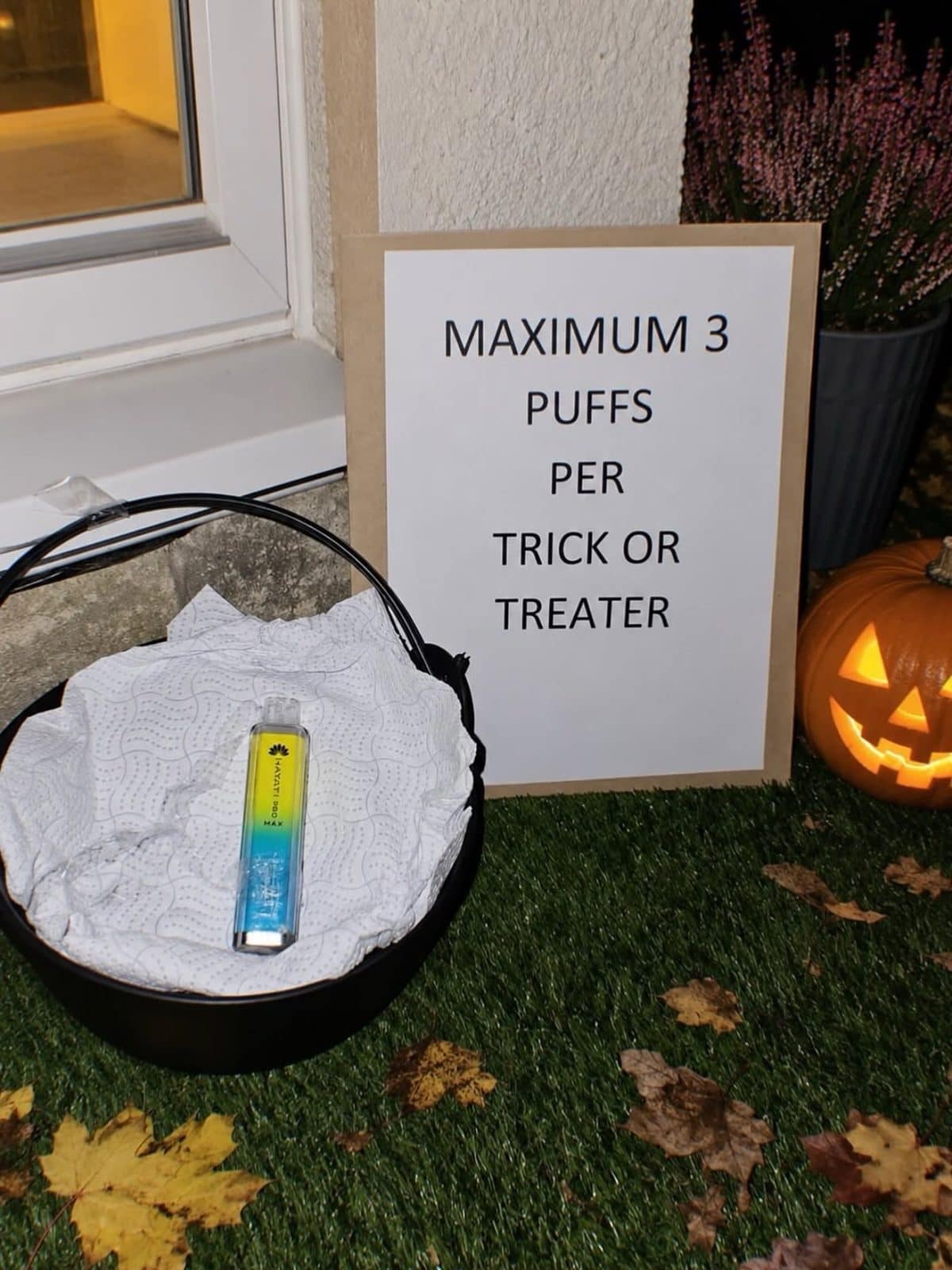 Halloween porch basket holding a vape with a sign allowing three puffs per trick-or-treater.
