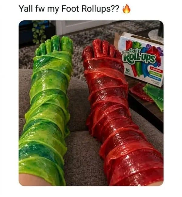 Feet and legs wrapped in green and red Fruit Roll-Ups with the snack box nearby