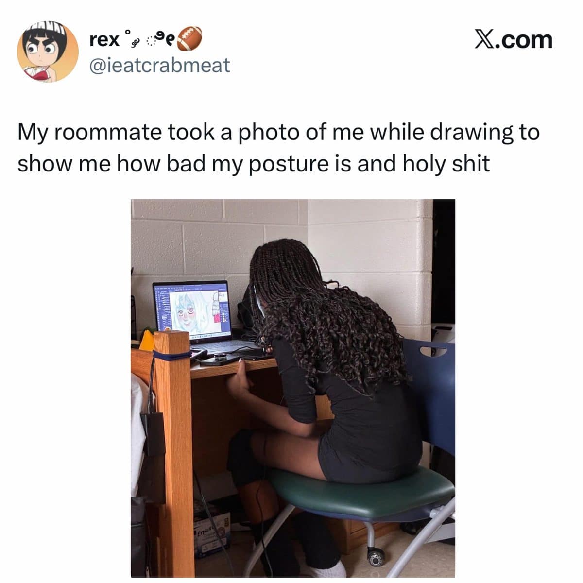 Roommate's photo of an artist hunched deeply over a dorm desk while drawing on a laptop.