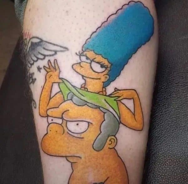 Leg tattoo of Marge Simpson pulling a green top over a grumpy Homer's head.