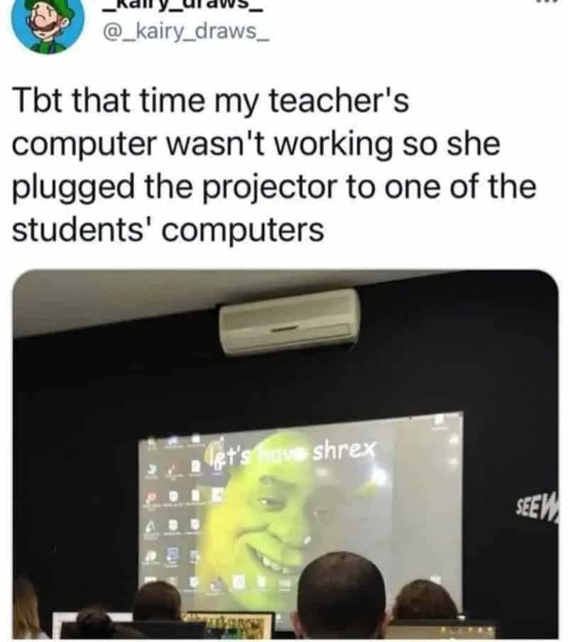 Teacher projects a student's computer screen and the desktop wallpaper is a giant smiling Shrek