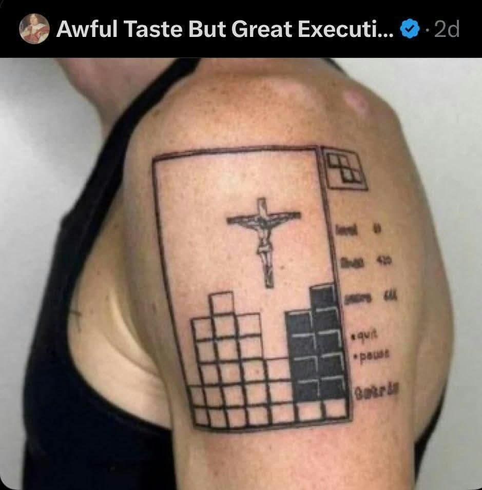 Shoulder tattoo of a crucifix dropping into a Tetris game board with stacked blocks