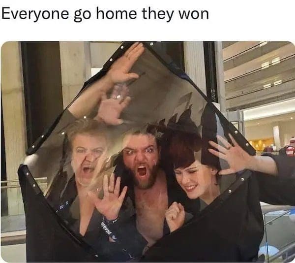 Three people pressed against a hanging mirrored panel, recreating the Phantom Zone from Superman II.