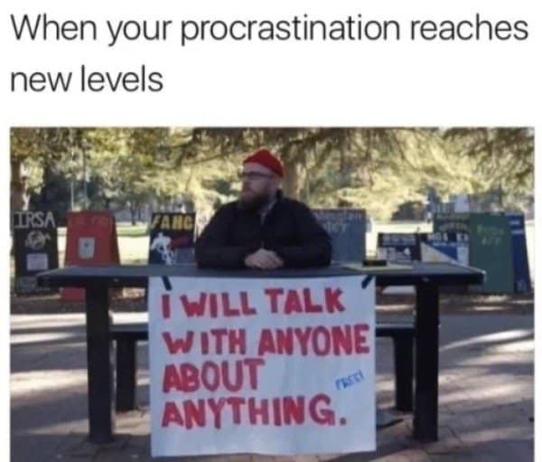 Man at a campus table with a sign offering to talk with anyone about anything