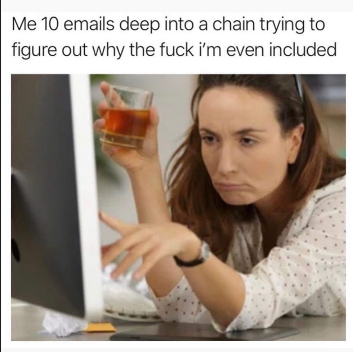Woman drinking whiskey at her computer, confused about why she is on an email chain.