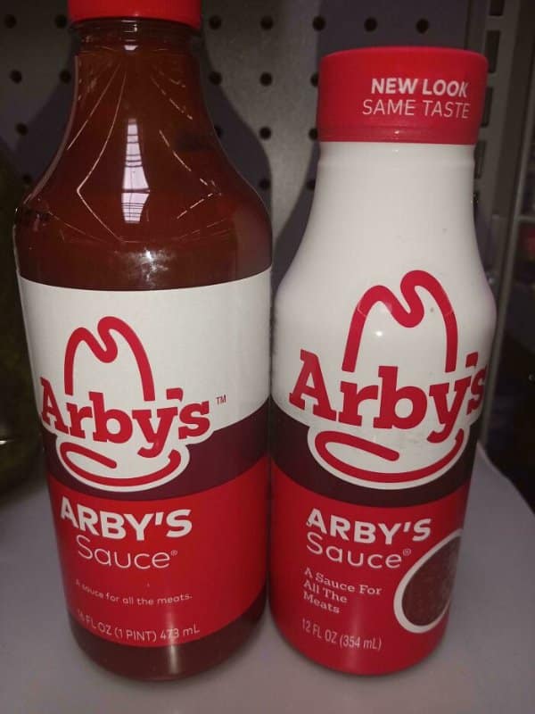 Two Arby's Sauce bottles, the newer one smaller with a label promising new look, same taste.