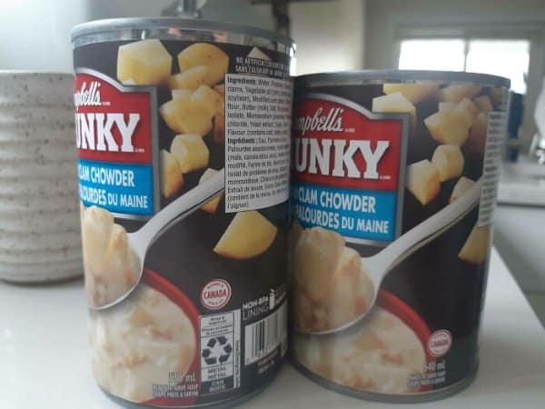 Campbell's Chunky clam chowder cans, the newer can visibly shorter than the old one.
