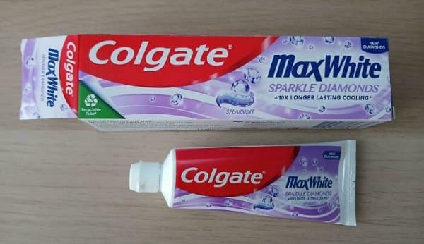 Colgate Max White box towering over a tiny toothpaste tube, one of the worst shrinkflation examples.