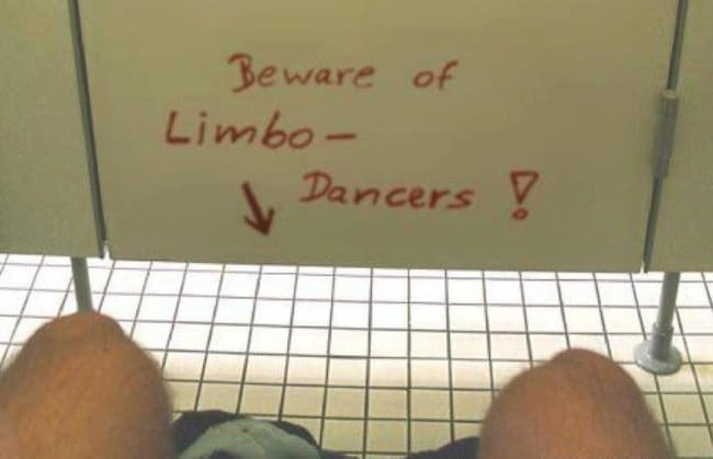 Bathroom stall graffiti warning beware of limbo dancers, with an arrow pointing under the door.
