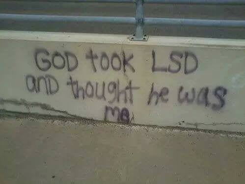 Graffiti on a highway barrier joking that God took LSD and thought he was me.