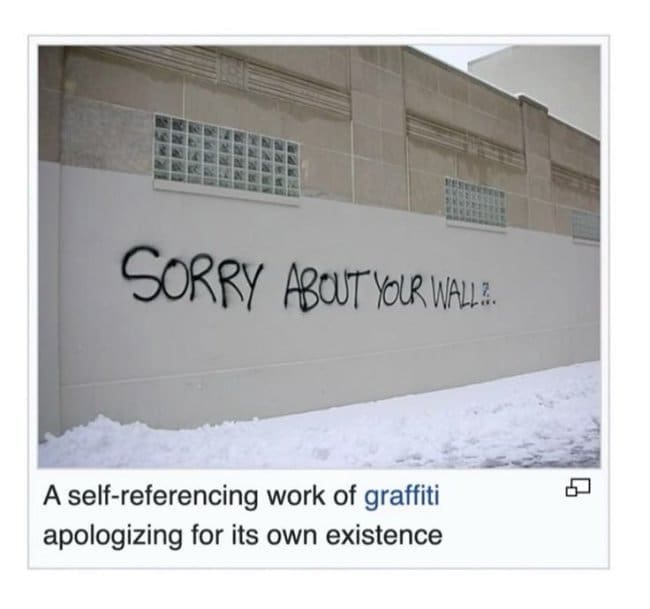 Wikipedia screenshot of graffiti reading sorry about your wall, an apology in paint.