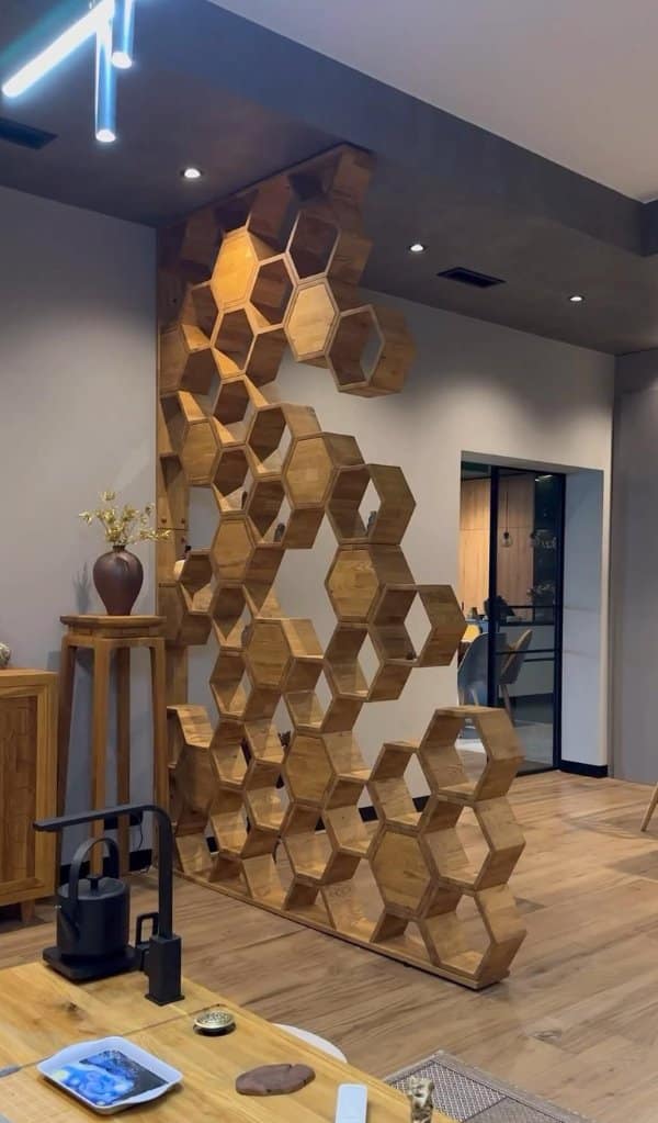 Wooden honeycomb room divider stacking hexagon shelves to the ceiling, among the unique designs here.
