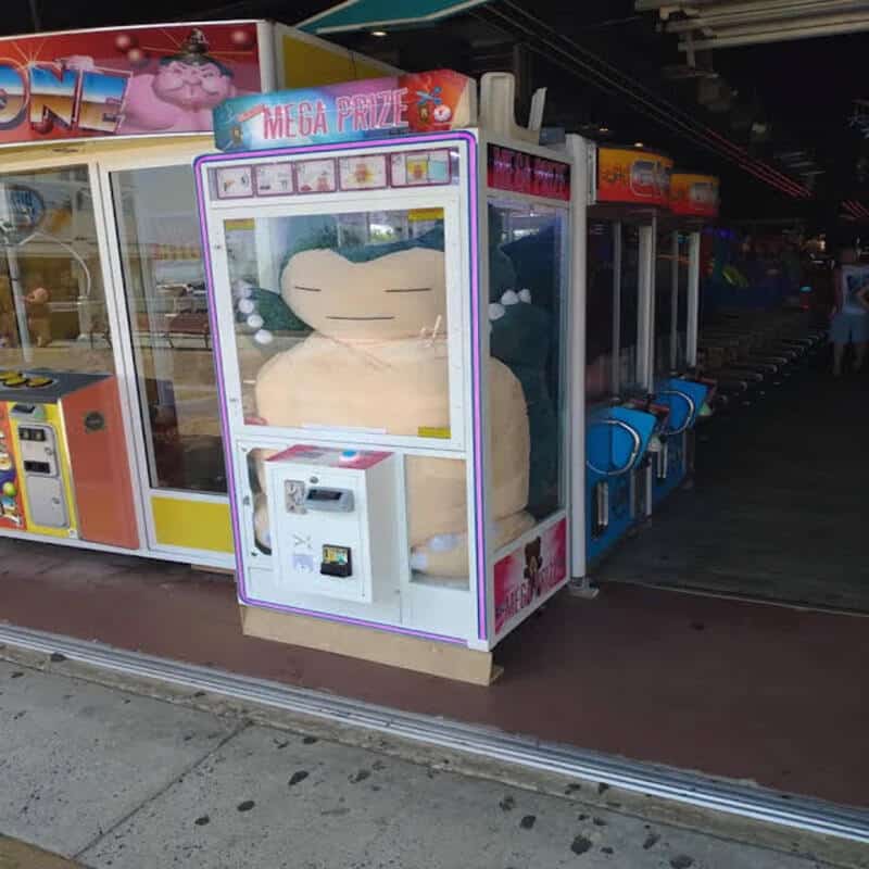 Arcade claw machine stuffed with one giant Snorlax plush that fills the entire case.