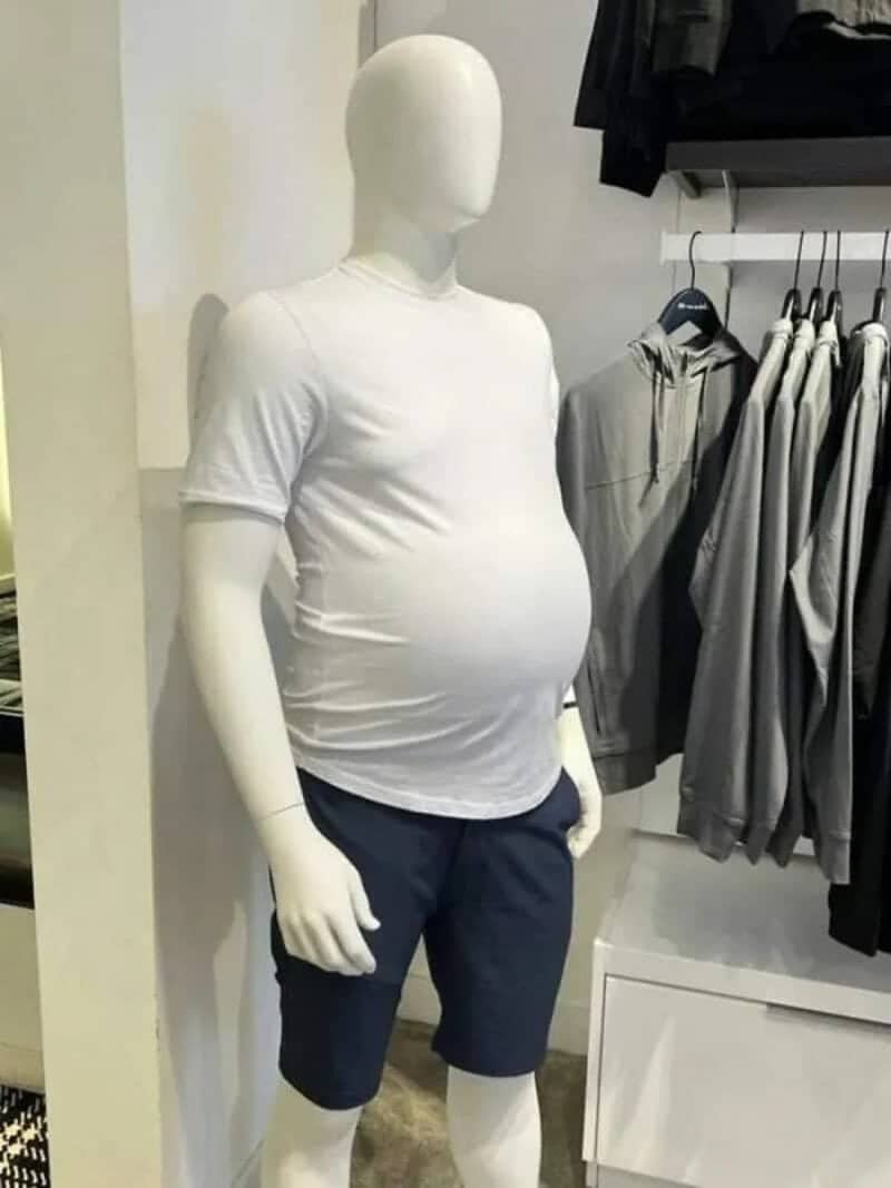 Store mannequin with a round dad belly wearing a white tee and navy shorts.