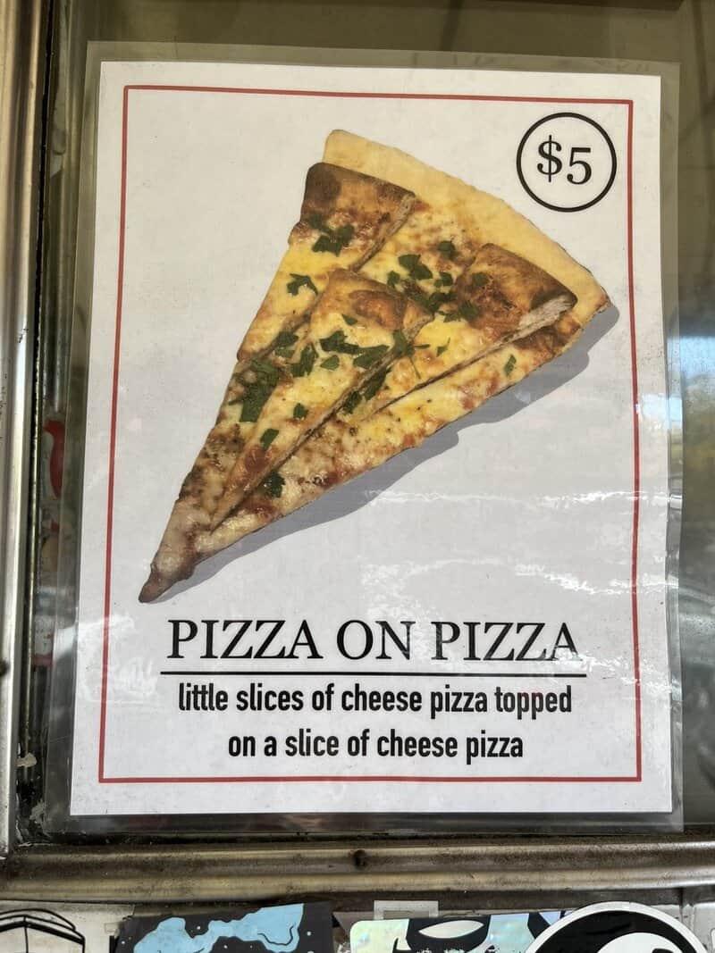 Pizza shop sign advertising pizza on pizza, little cheese slices on a cheese slice.