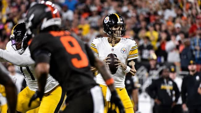 Steelers quarterback in the pocket with his face edited into a grinning skeleton as defenders rush in.