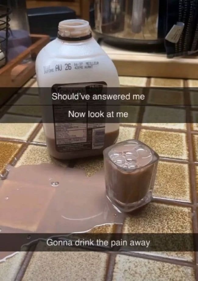 Spilled chocolate milk beside a full shot glass, captioned like a heartbroken late night text.