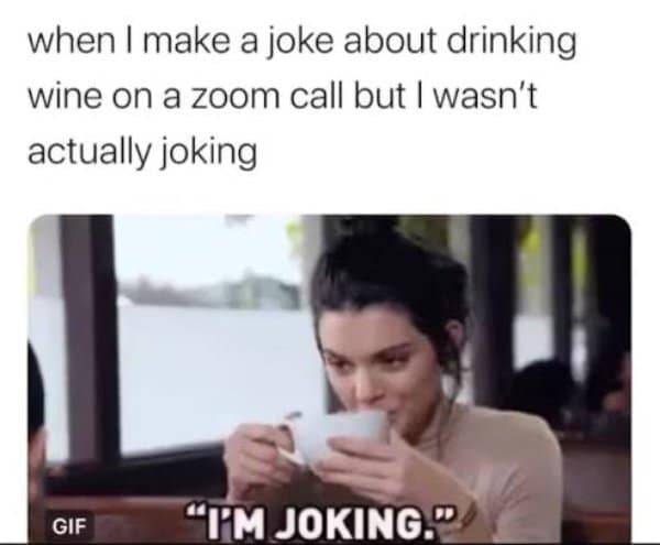 Woman sipping from a mug saying I'm joking after a wine comment on a Zoom call.
