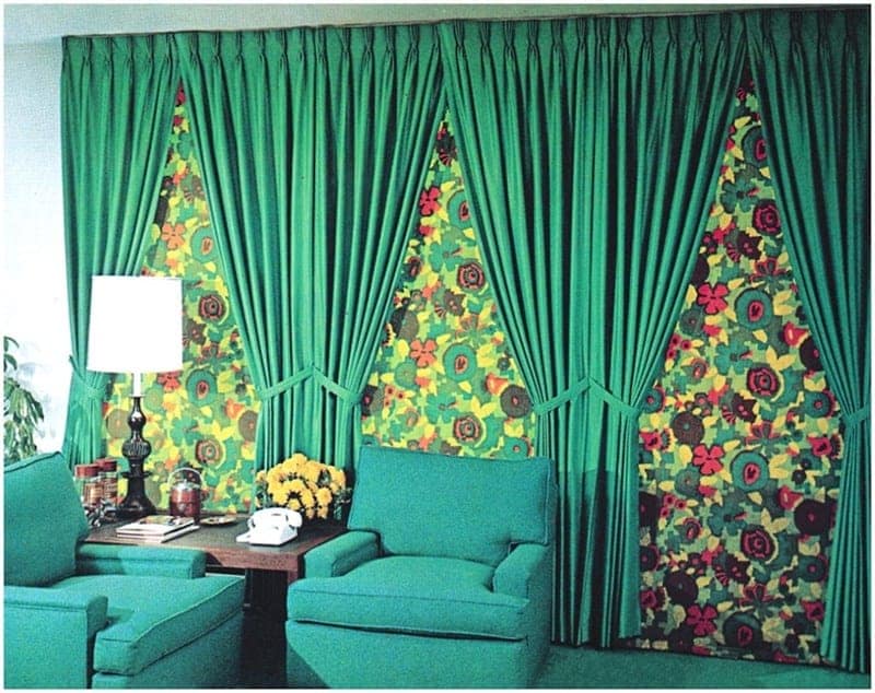 Vintage green living room with floral patterned curtains and retro armchairs