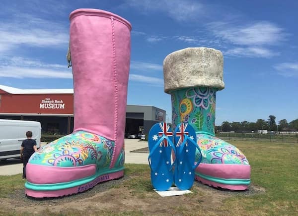 Colorful giant boots and flip-flops displayed outside a museum.