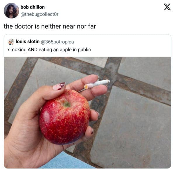 Hand holding a red apple and a lit cigarette at once.