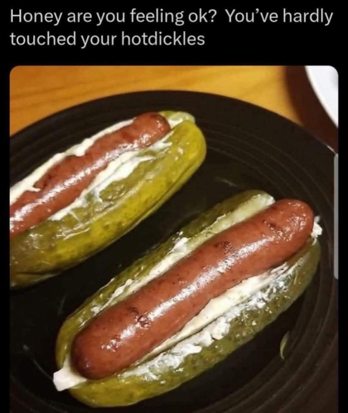 A cursed and unsettling food photo of two "hotdickles," which are two cooked hot dogs that have been served inside of large, hollowed-out pickle "buns."