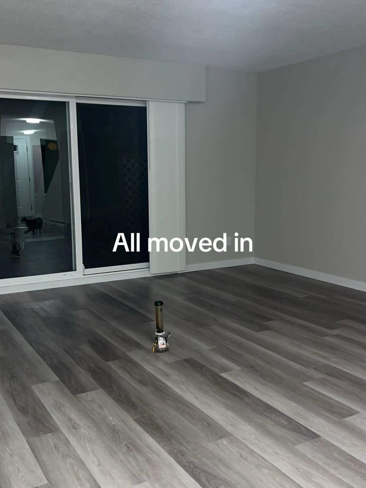 A funny and extremely relatable photo of a completely empty apartment, with the only piece of furniture being a single bong in the middle of the floor