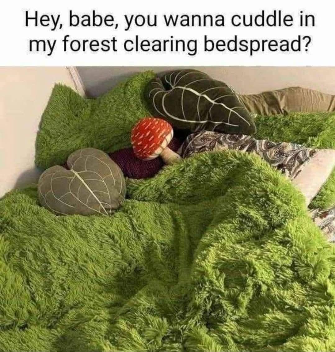 A funny picture of a very cozy bed made to look like a forest clearing with a green shag blanket.
