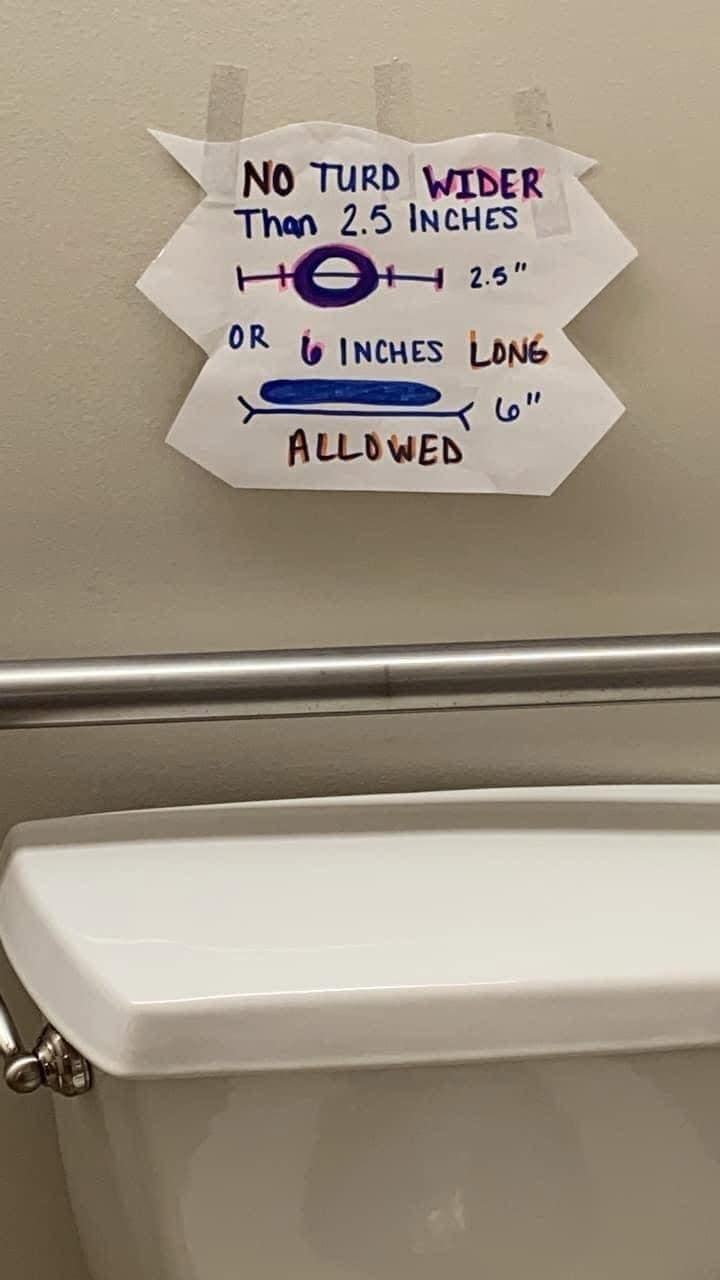 A hilarious handmade sign above a toilet that gives very specific dimension restrictions for bowel movements.