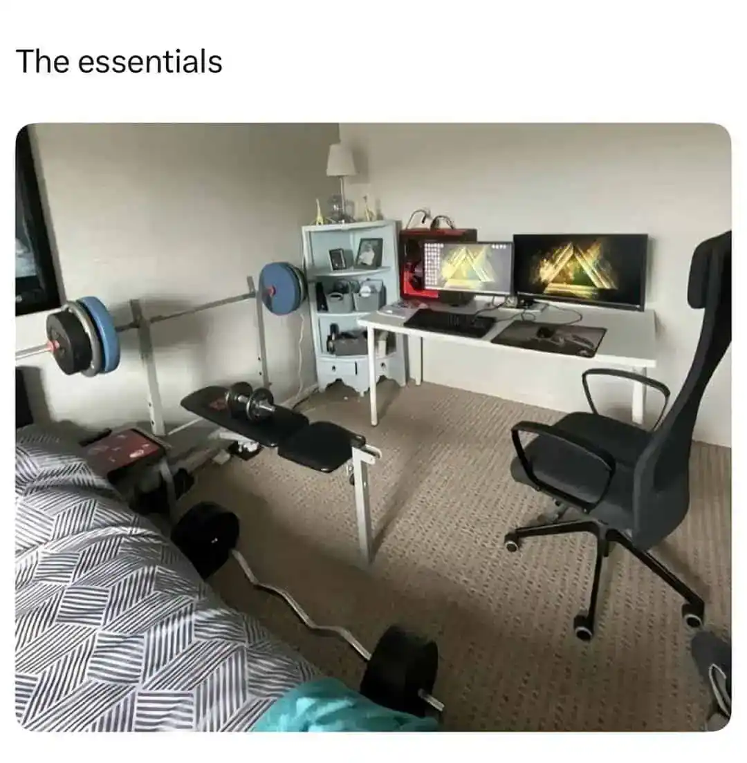 A photo of a bedroom setup with just a gaming PC and a weight bench titled The Essentials.