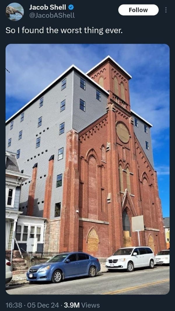 Architectural fail blending a modern gray apartment building into an old brick church.
