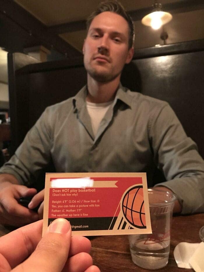A tall people problems business card handing out answers to FAQs like "Do you play basketball?" and "How's the weather?".