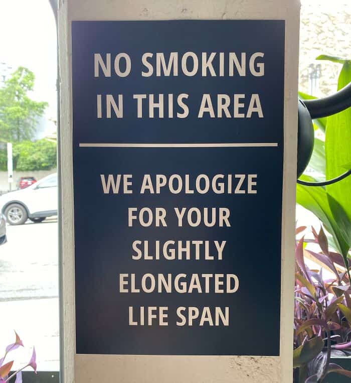 No smoking sign featuring a snarky apology for the customer's slightly elongated life span.