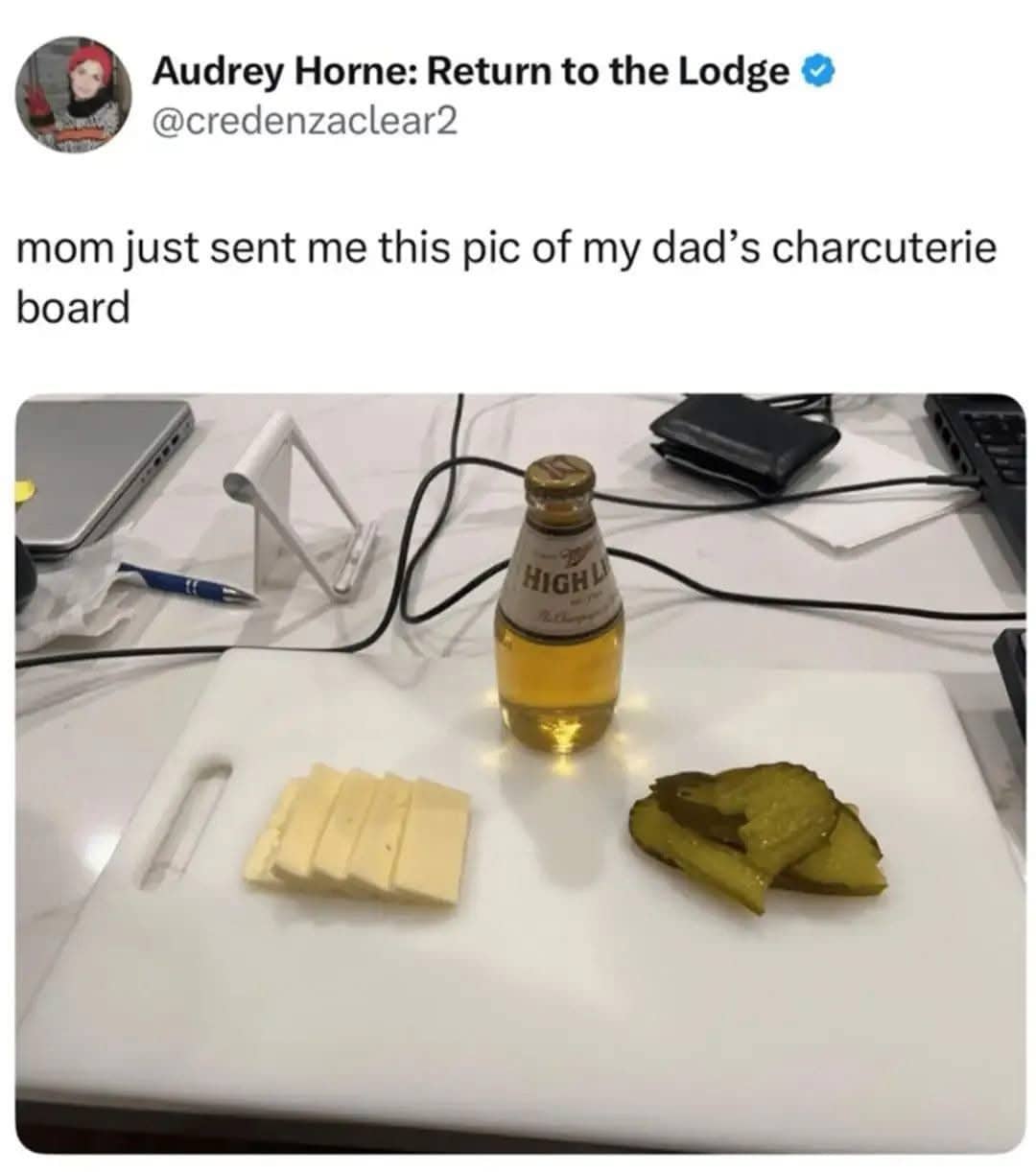Humorous photo of a "dad charcuterie board" featuring cheese slices, pickles, and a High Life beer.